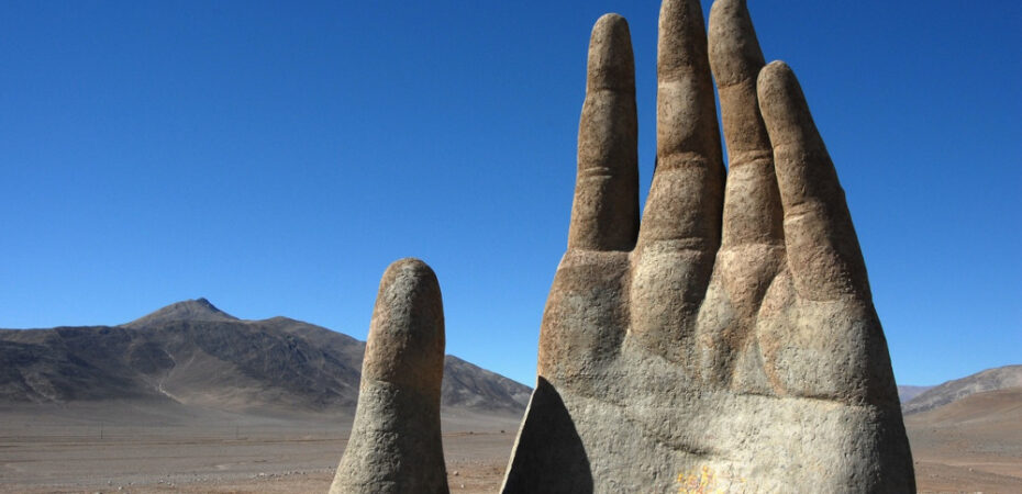 Photo of a hand sculpture emerging from the Atacama desert, Chile.
