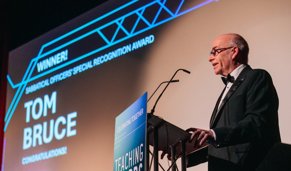 Photo of Stephen Warrington accepting Teaching Award on behalf of Tom Bruce
