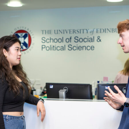 Students talking by reception in the Chrystal Macmillan building, School of Social and Political Science.