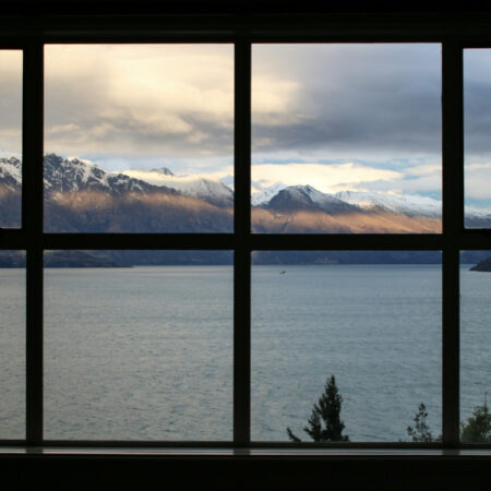 Window panes looking onto lake and snowy mountains