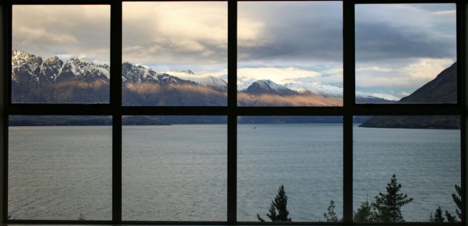 Window panes looking onto lake and snowy mountains