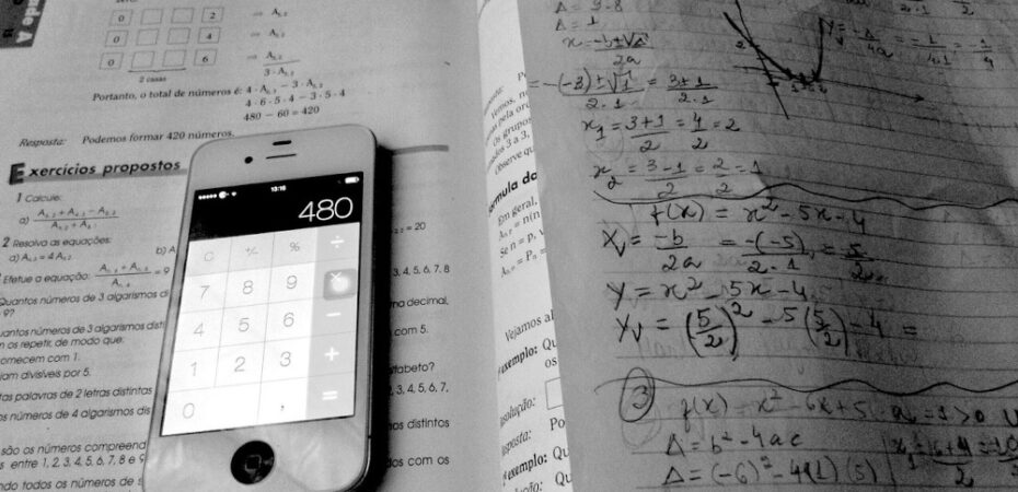 Photo of calculator lying on a maths workbook
