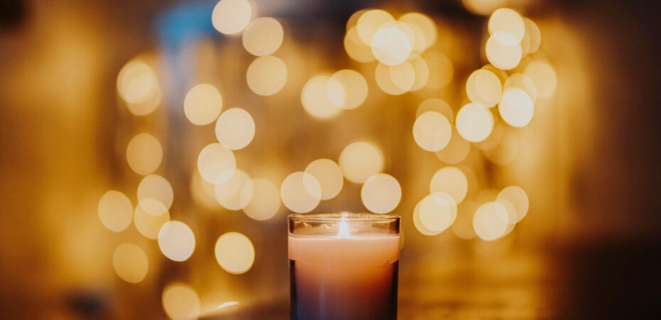 Image of candle in focus, and fairy lights blurred in background