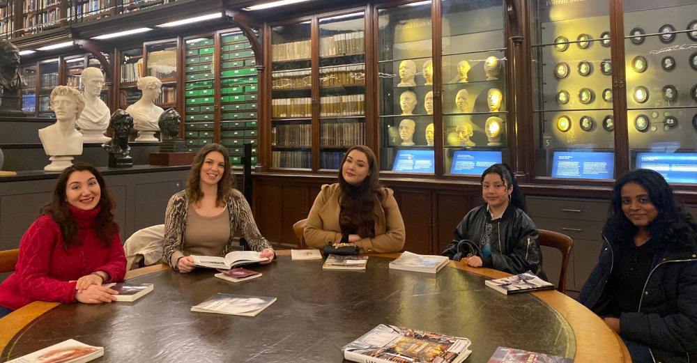 Mature Access students sitting around table with books in front of them. 