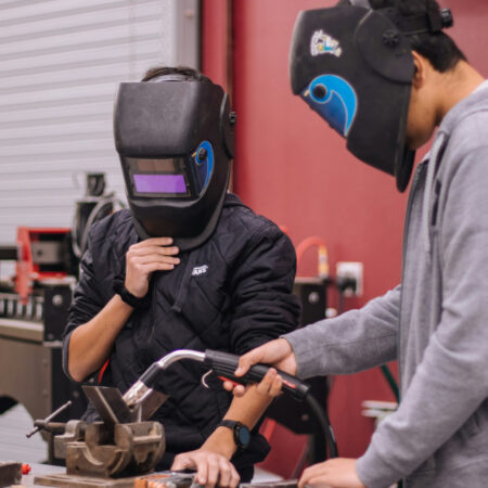 Photo of two people welding