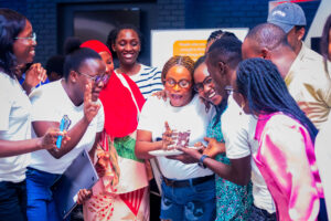 Celebrating a birthday, surrounding person with a piece of cake on a plate