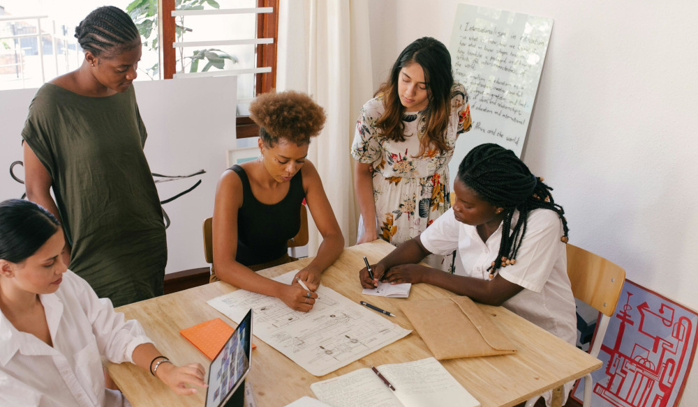 People planning around table with pens, paper and ipad.