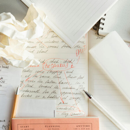 Note books written on with lots of rough notes paper scrunched up.