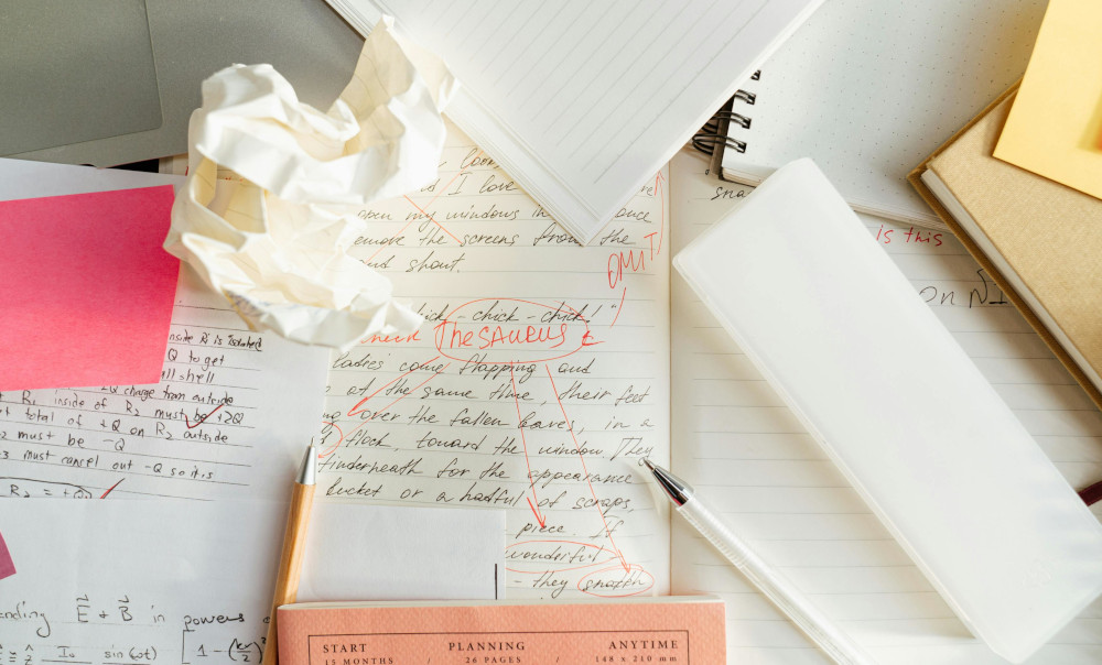 Note books written on with lots of rough notes paper scrunched up.