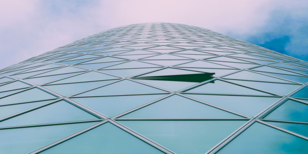 A photo looking upwards at a glass-sided building