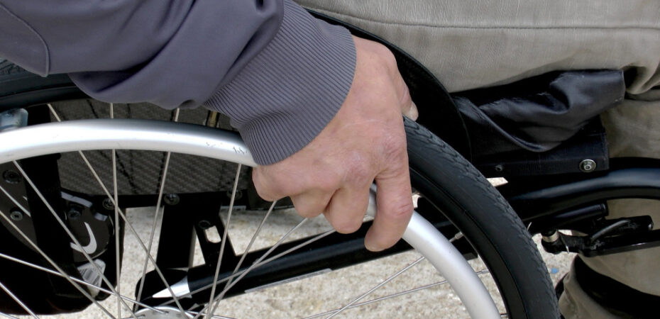 Photo of man in wheelchair zoomed in with his hand on wheel