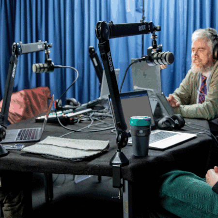 Photo of 3 colleagues sitting around podcast table in podcast studio.