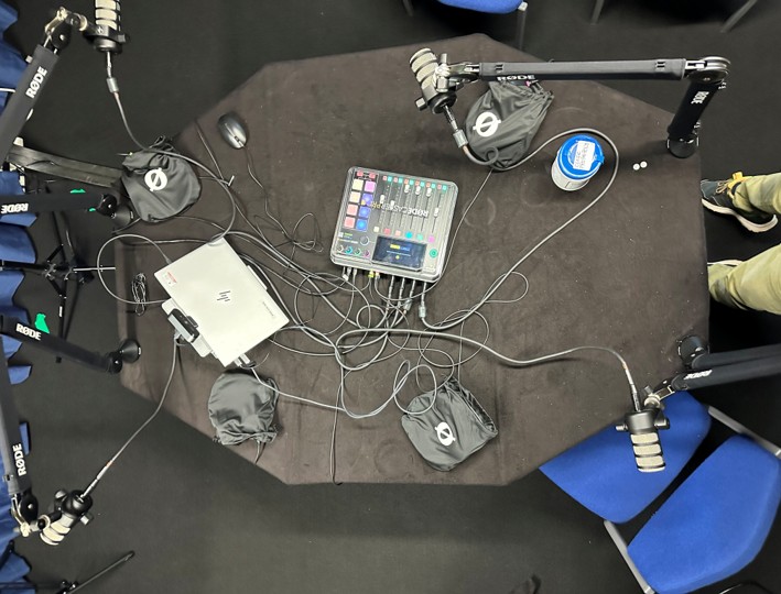 Photo of birds-eye view of podcasting table and the tech equipment.