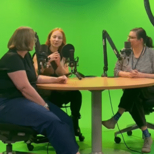 Photo of authors around table with mics recording a podcast episode.
