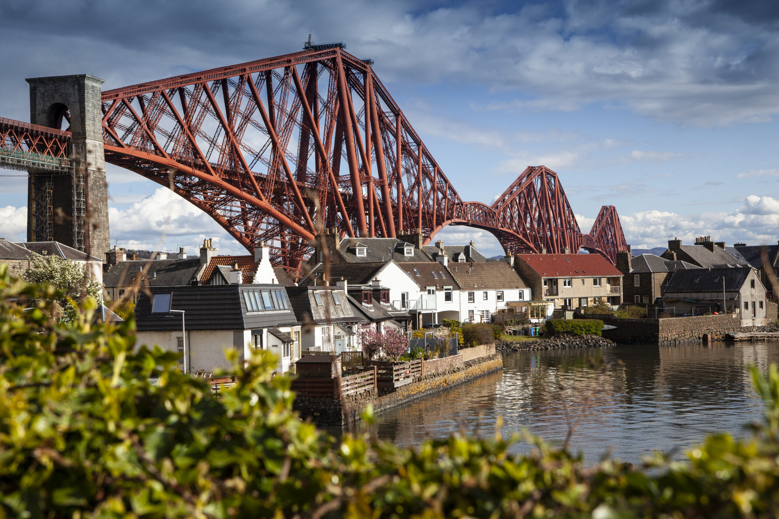Red bridge with houses and gorse in the foreground
