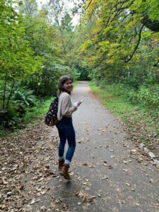 Student walking on tree-lined path