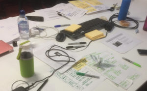 Desk covered in user interface sketches and stationery