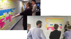 Staff discuss user research while looking at information on a wall