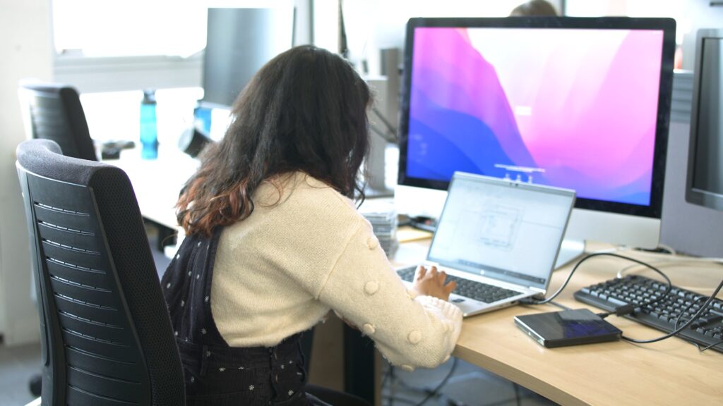 Intern processing CDs at laptop