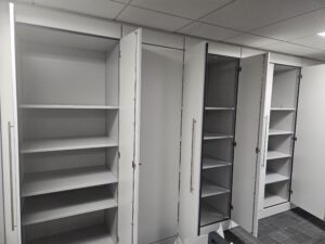 white and grey floor to ceiling cupboards with the doors open showing empty shelves
