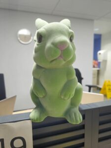 A flocked green figurine of a rabbit