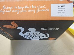 A large orange and black box of 440 Clipper branded tea bags. The focus is on the use by date 