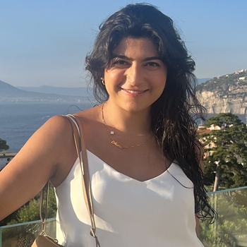 Portrait of Mona in front of a coastal landscape