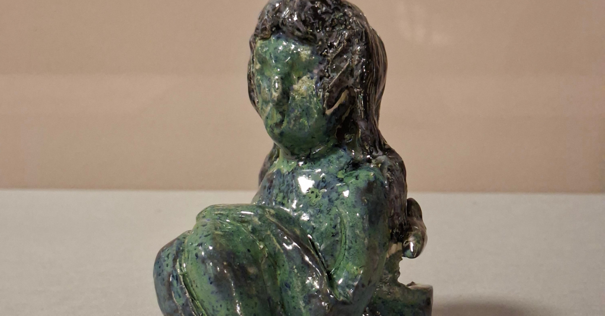 A close-up of a ceramic selkie in shades of blue and green, part of the Lacuna project.