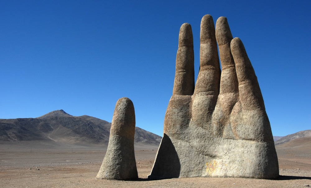 Photo of a hand sculpture emerging from the Atacama desert, Chile.