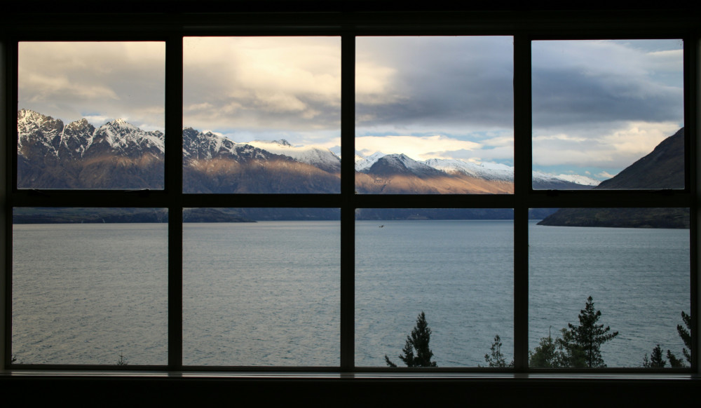Window panes looking onto lake and snowy mountains