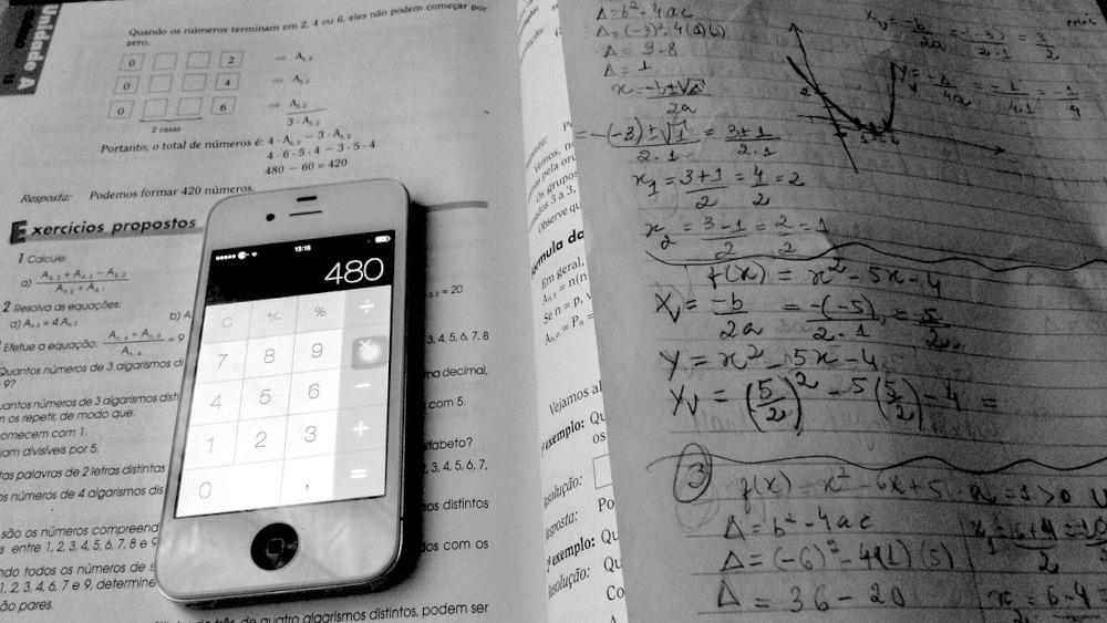 Photo of calculator lying on a maths workbook