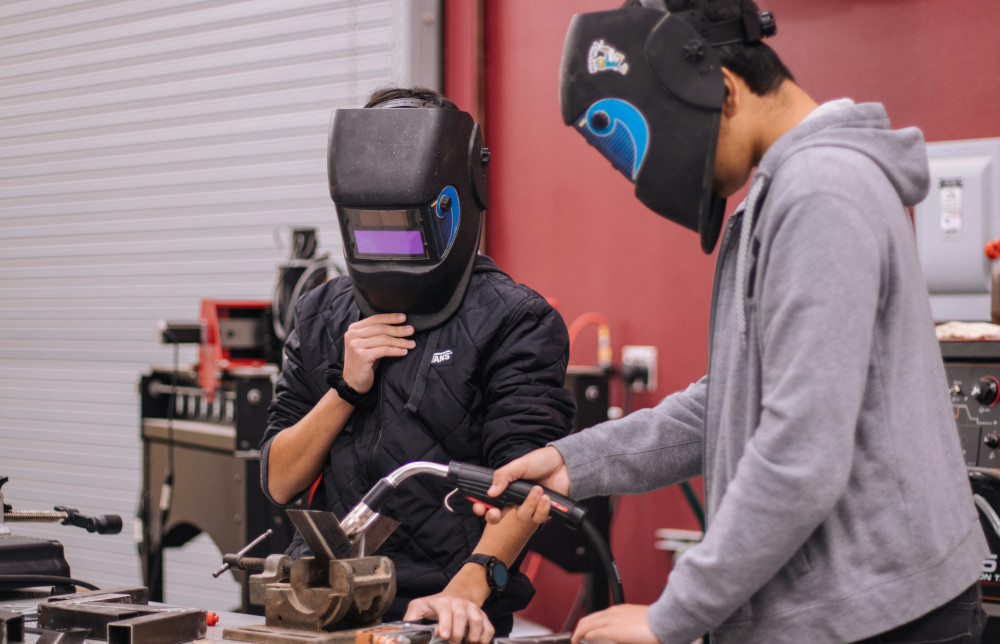 Photo of two people welding