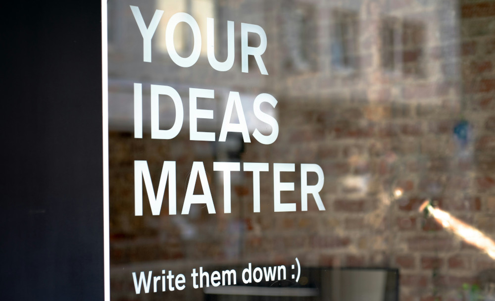 Window with words 'Your ideas matter - Write them down :)' written in white