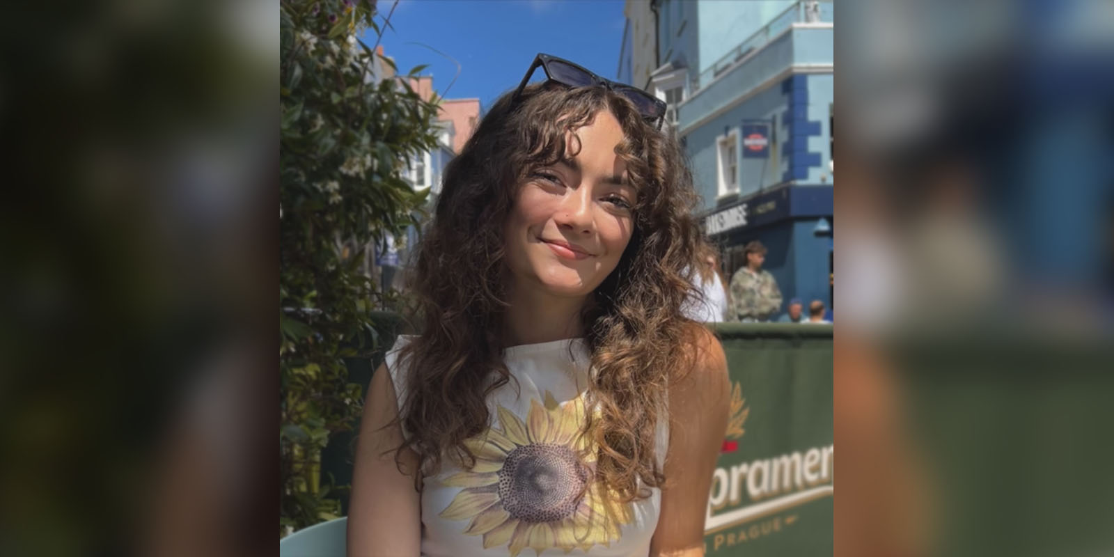 Efe sits at a table outside on a sunny day.