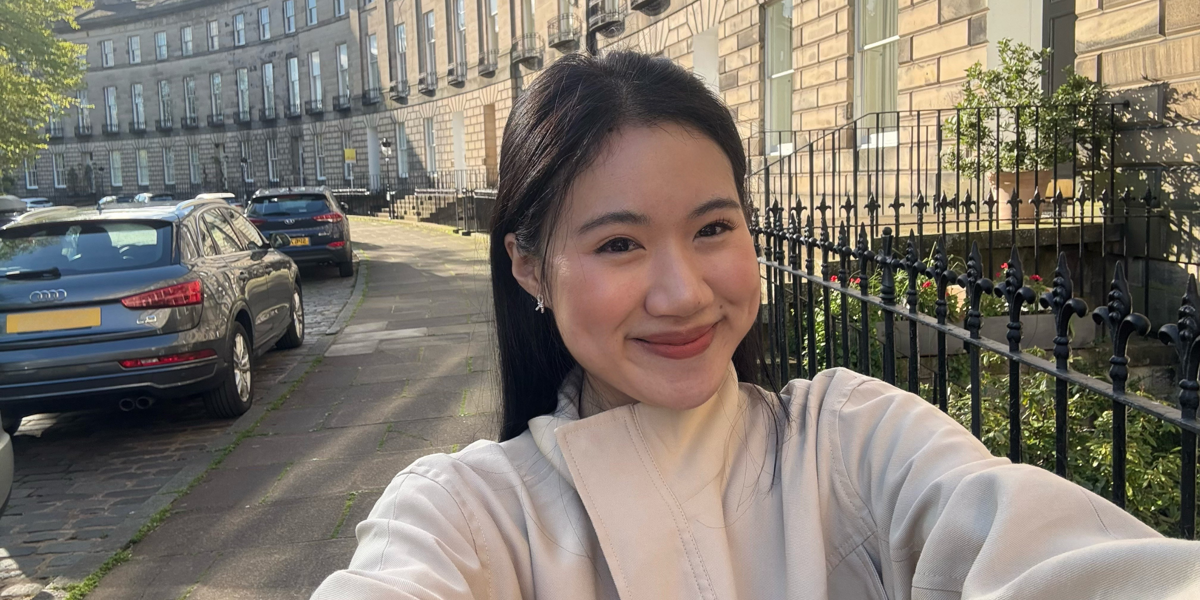 A person smiling, taking a selfie.